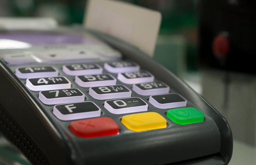 Close-up of a cashless countertop terminal with a card in the reader